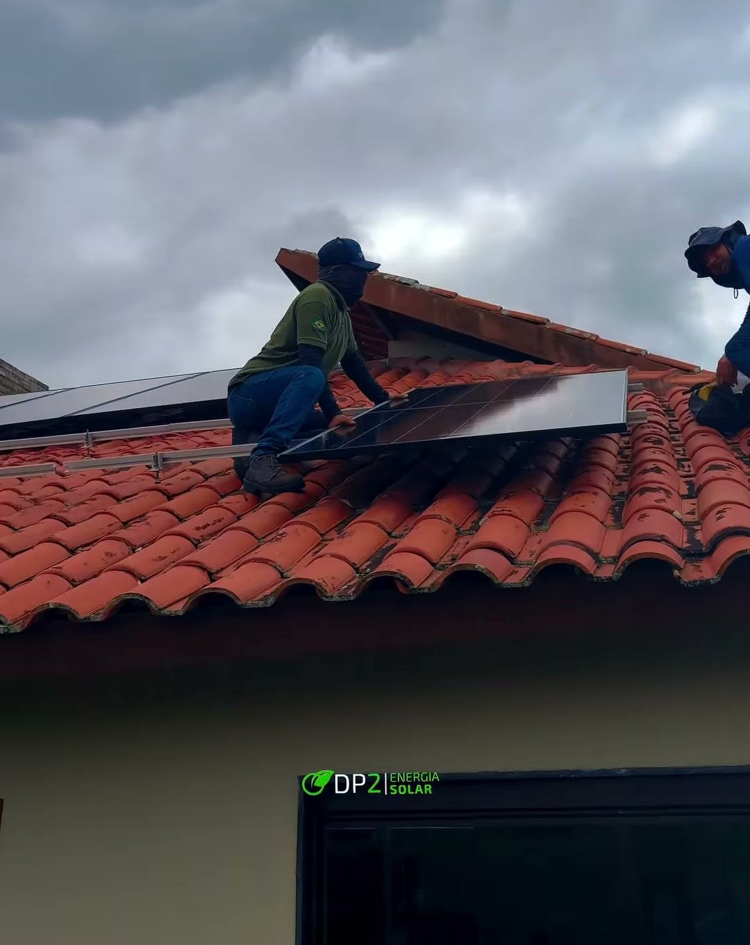 Técnicos da DP2 instalando módulos solares em telhado de telha cerâmica em Gravatá